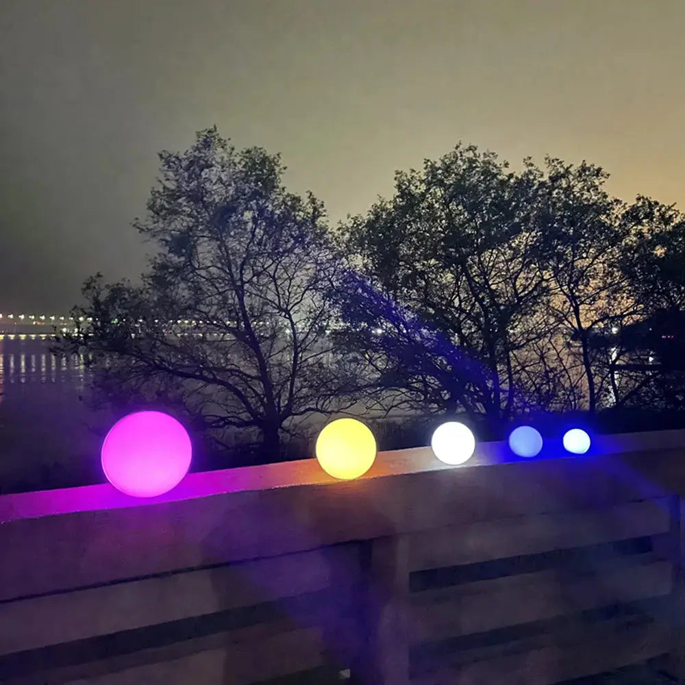 Colorful solar-powered orbs illuminated on a terrace at night, enhancing outdoor ambiance with eco-friendly lighting.