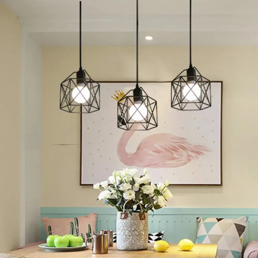 Modern black geometric pendant lights hanging above a dining table with flowers and artwork in a cozy interior setting.