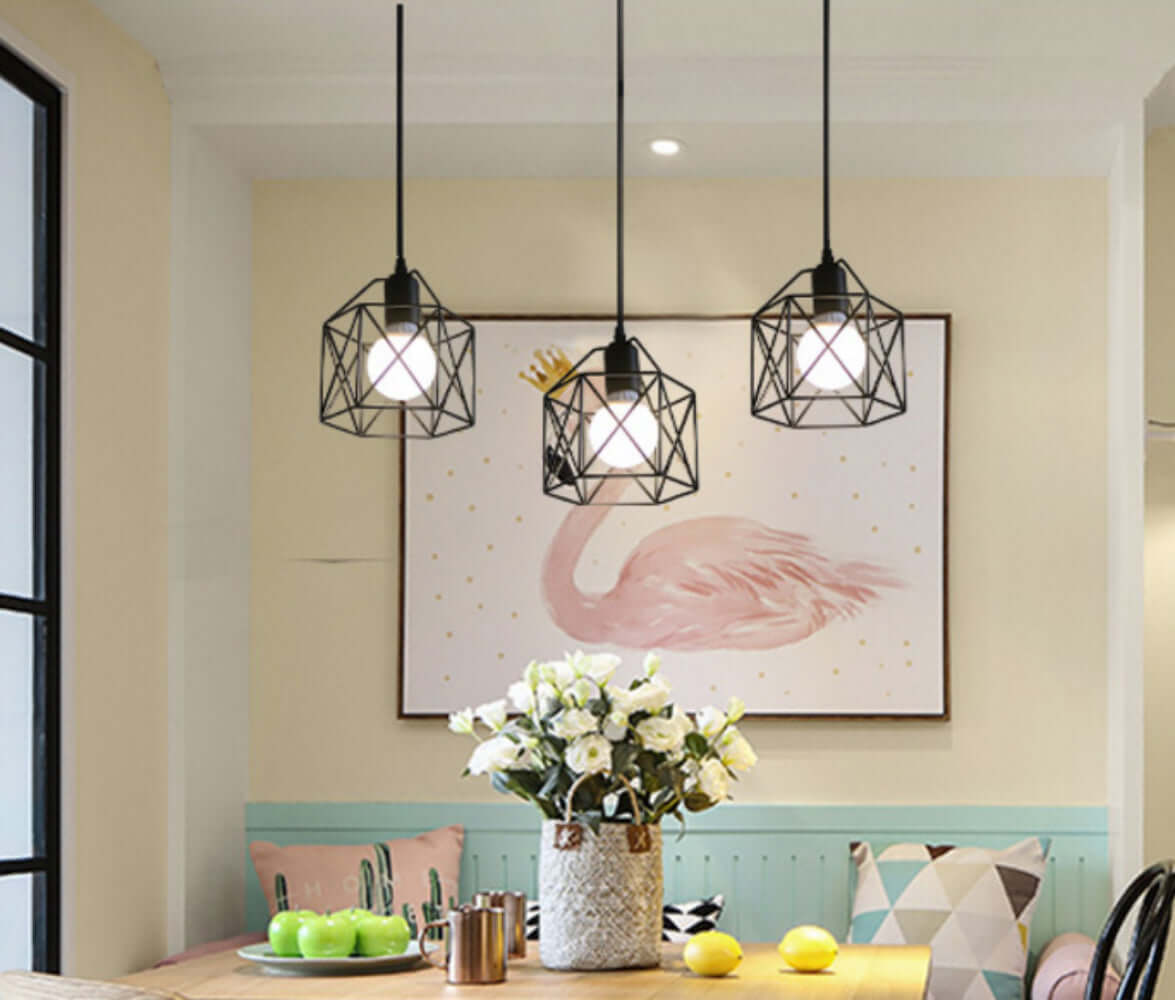 Modern hanging pendant lights in a cozy dining area, featuring a floral centerpiece and a decorative wall art.